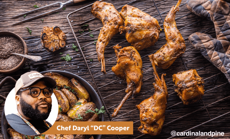 A rack of roasted rabbit on a grill is in the foreground, with an inset of Chef Daryl 'DC' Cooper in the lower left corner