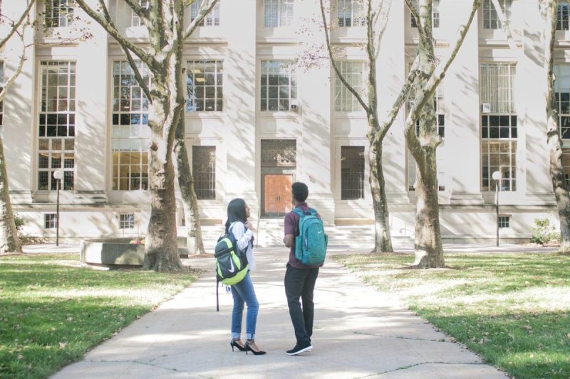 College students standing outside an academic building.