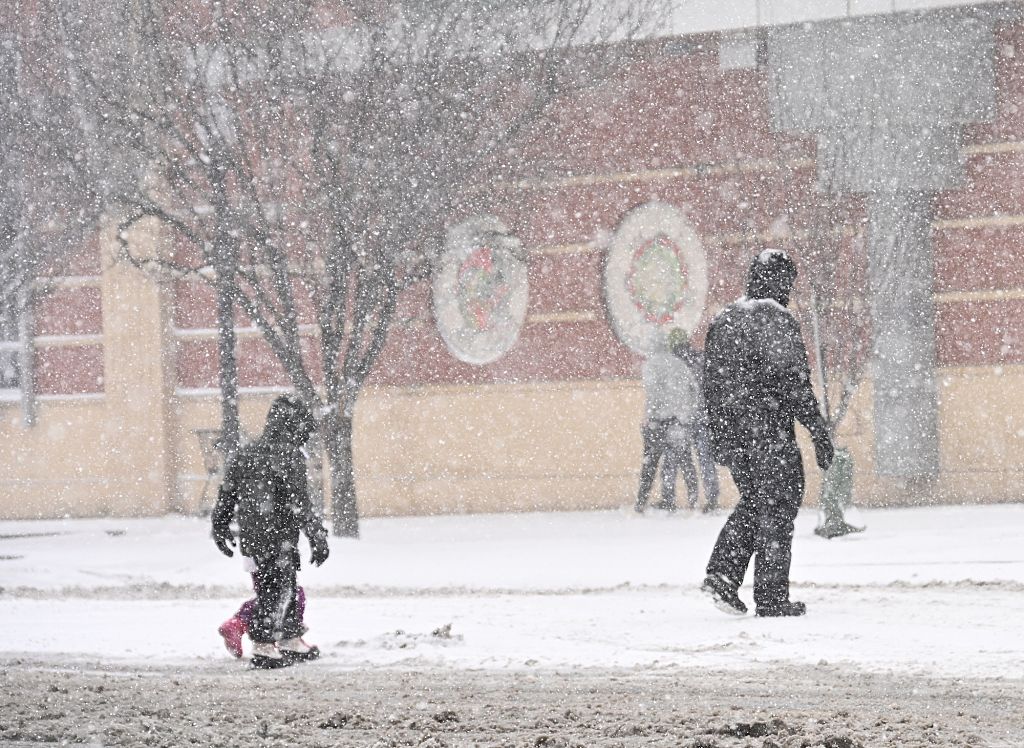 Photo of a father and his children walking in the snow in North Carolina