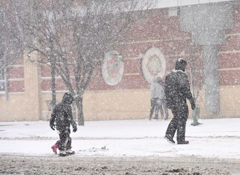 Photo of a father and his children walking in the snow in North Carolina